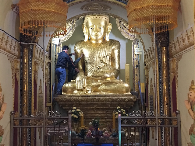 インディン遺跡内の仏像に金箔を貼る男性